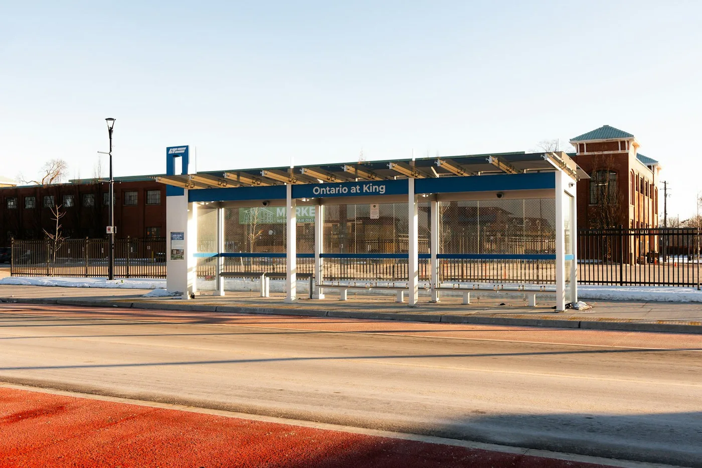 Modern bus shelter with a bench beside a city street
