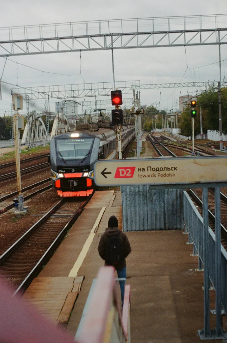 Passenger waiting at a transport station representing staged automotive AI deployment across mobility services