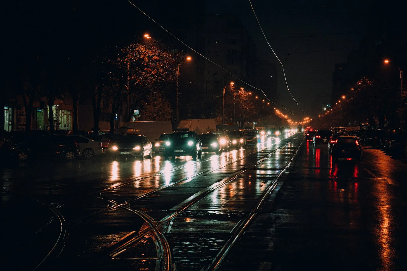 Cars moving through a rainy city at night for adverse-condition simulation testing