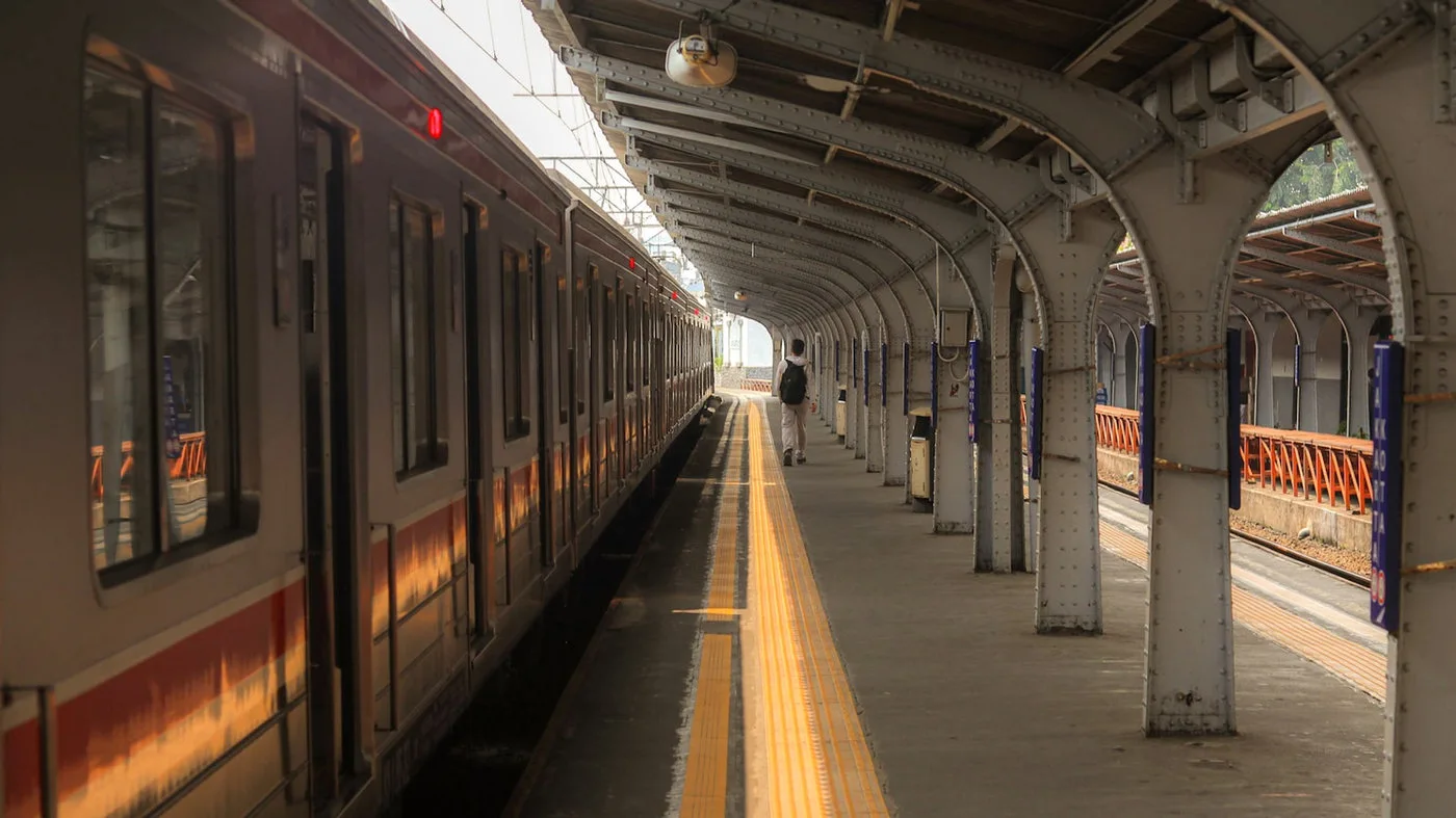 Passenger at a train platform representing automotive AI across connected mobility journeys