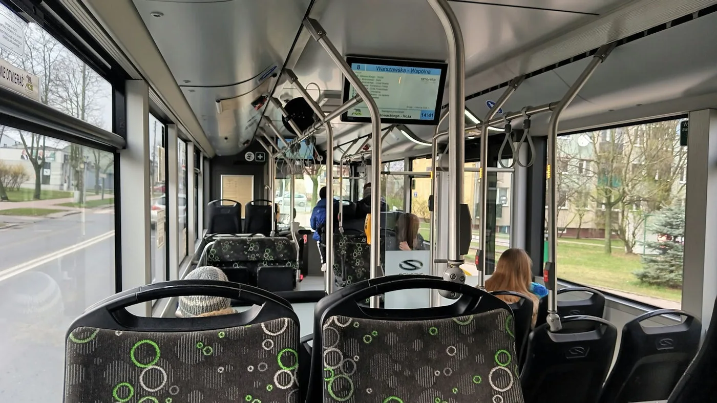 Modern bus station with people waiting near a parked bus