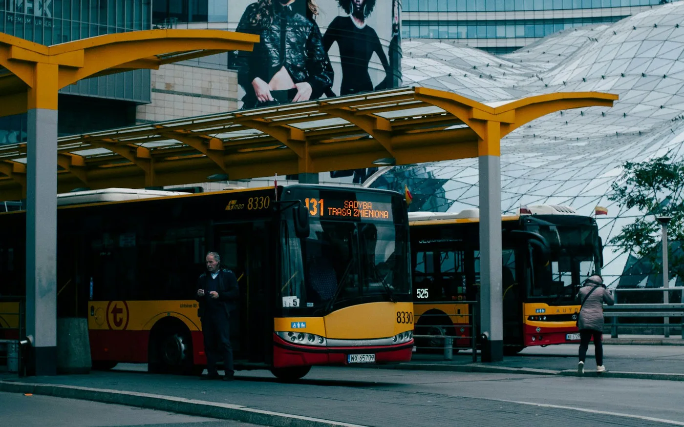 City bus waiting at a stop near an urban terminal